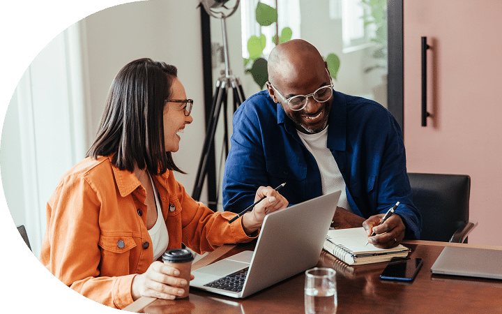 two-people-at a desk-laughing Two people at a desk laughing